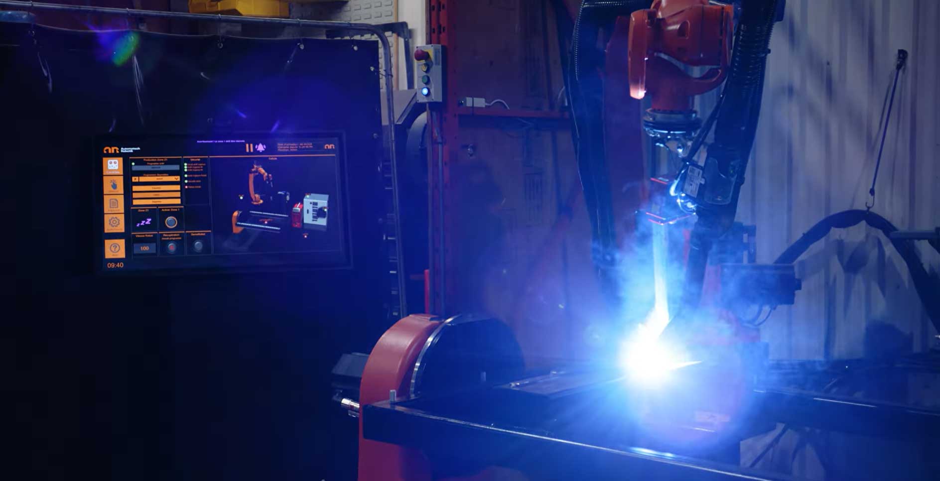 Robotic welding cell with OCTOPUZ software displayed on monitor.