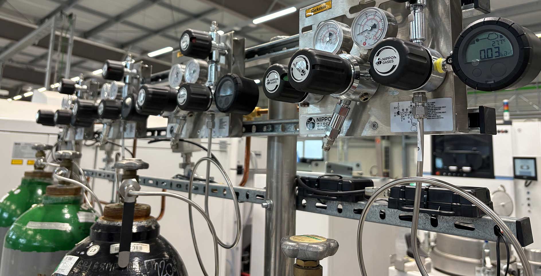 Industrial gas monitoring system with pressure regulators, flow measurement devices, and gas cylinders at the chesco ZWE research facility.